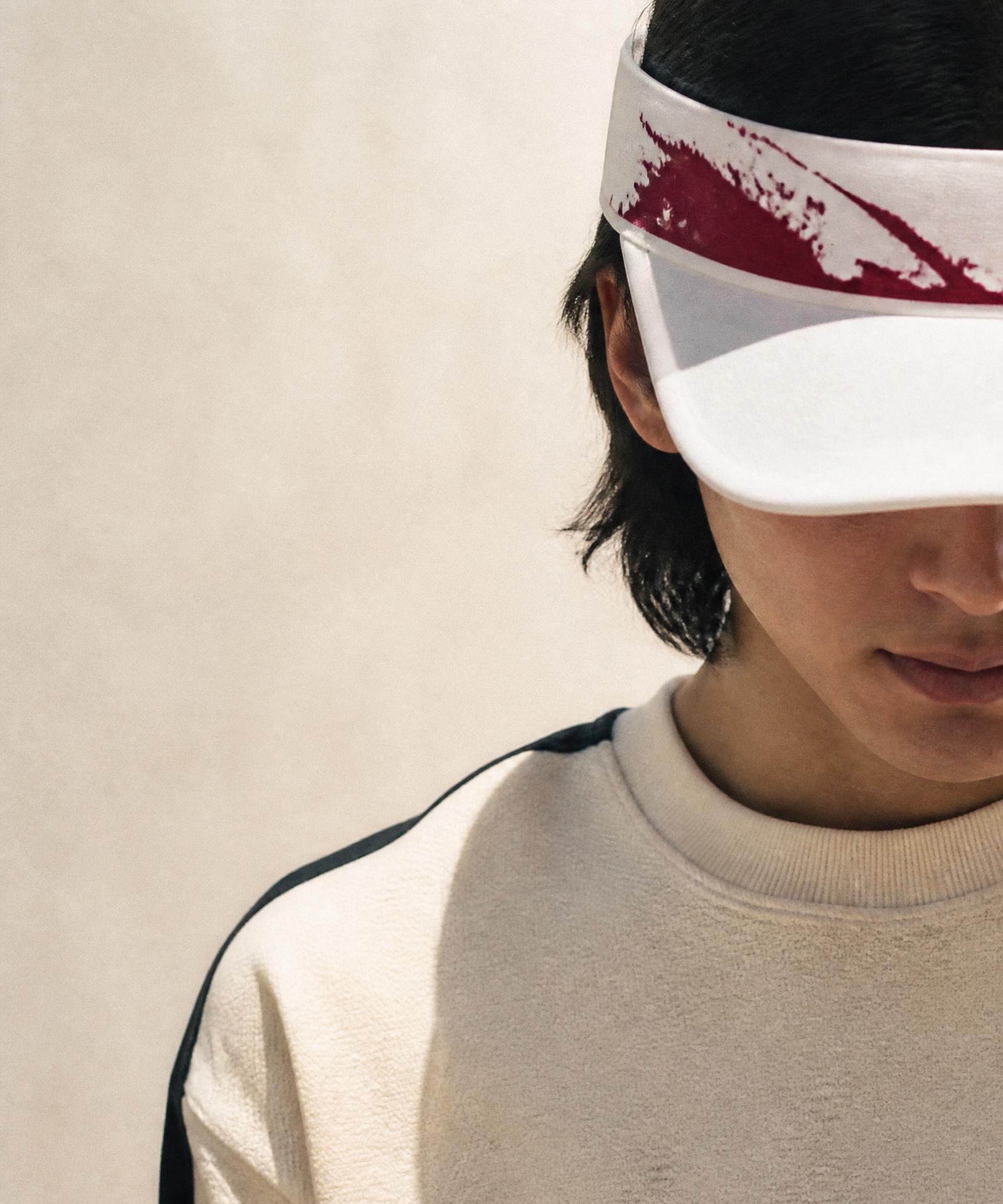Model wearing The Blood Visor in white with a red mark across the front band